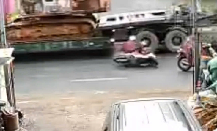 Hai cô gái đi xe máy ngã vào xe container tử vong trong trời mưa - Ảnh 1.