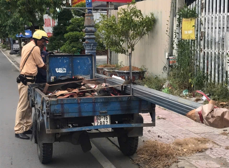 Cảnh sát giao thông TP.HCM xử lý xe ba gác chở tôn dài ngoằng trên đường - Ảnh 4.
