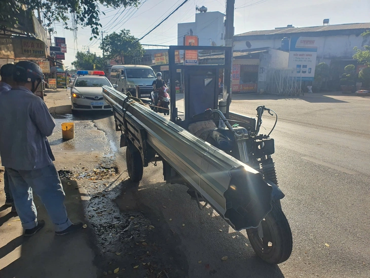 Cảnh sát giao thông TP.HCM xử lý xe ba gác chở tôn dài ngoằng trên đường - Ảnh 1.
