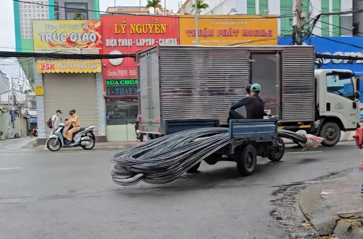 Cảnh sát giao thông TP.HCM xử lý xe ba gác chở tôn dài ngoằng trên đường - Ảnh 6.