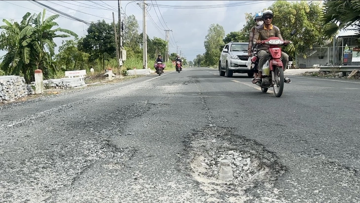 Đường Xuyên Á bể nát, dân vất vả quét đá bụi lấp ổ gà cho xe đi lại - Ảnh 4.