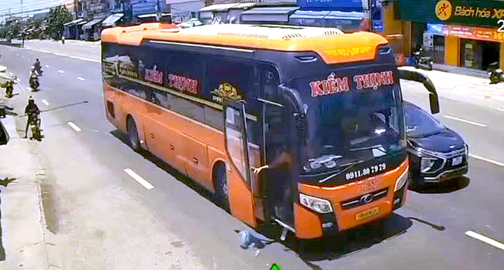 Dừng đèn đỏ trên quốc lộ 1, nhân viên xe khách thản nhiên vứt rác xuống đường - Ảnh 1.