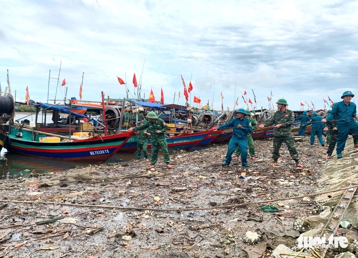 Bộ đội cùng ngư dân chằng buộc tàu thuyền ứng phó bão số 5 - Ảnh 1.