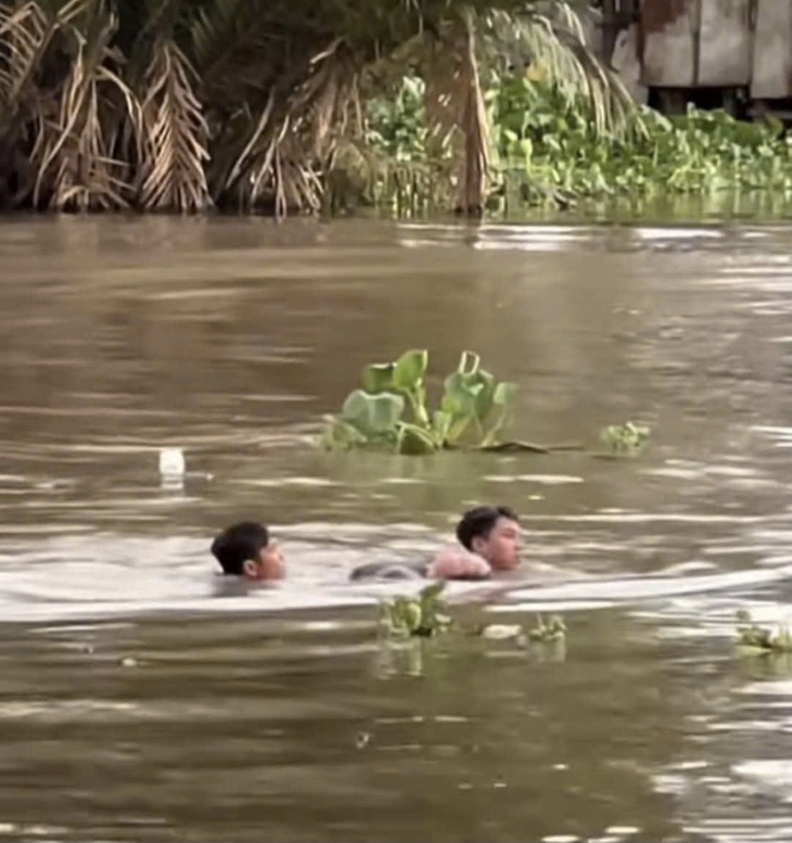 Hai thanh niên nhảy sông cứu người phụ nữ đuối nước - Ảnh 1.