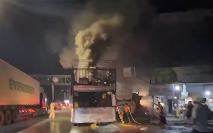 Xe tải chở gỗ bốc cháy, cảnh sát đeo mặt nạ chống độc để dập lửa - Ảnh 4.