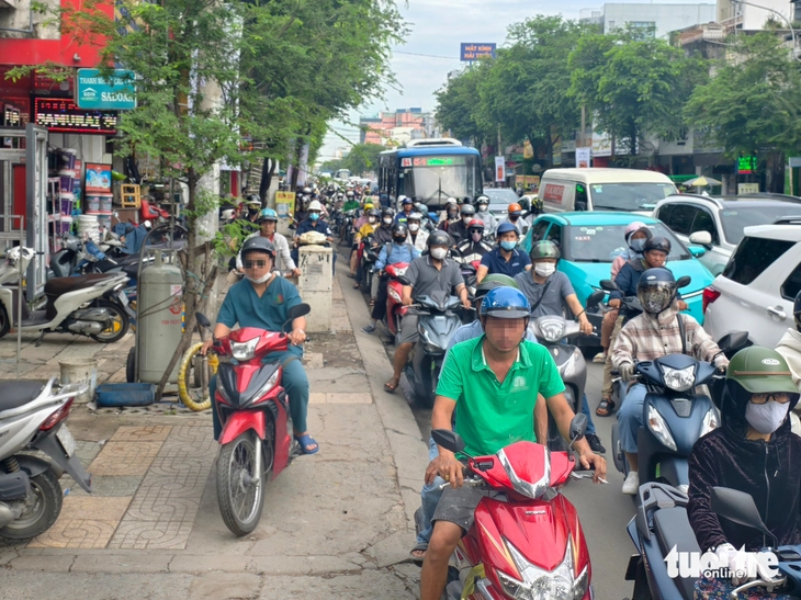 Xe chạy lên vỉa hè, đến đoạn hết đi được lại chen xuống trước xe đang chờ, sao mà không kẹt  - Ảnh 1.