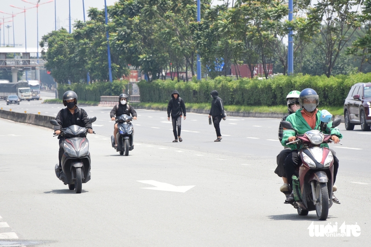 Sinh viên bất chấp băng qua đường Võ Nguyên Giáp để đến trường gần hơn - Ảnh 2.