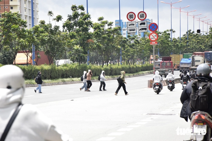 Bị xử phạt, sinh viên vẫn đi bộ băng qua đường Võ Nguyên Giáp - Ảnh 1.