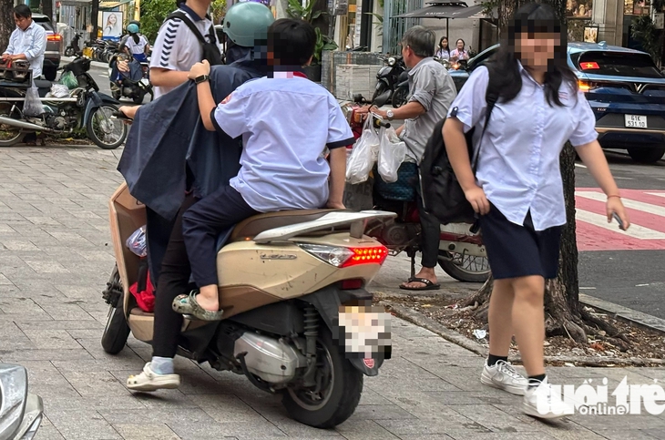 Nhiều phụ huynh 'vô tư' chở con chạy ngược chiều, leo vỉa hè, không đội mũ bảo hiểm đến trường - Ảnh 3.