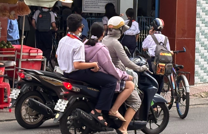 Nhiều phụ huynh 'vô tư' chở con chạy ngược chiều, leo vỉa hè, không đội mũ bảo hiểm đến trường - Ảnh 4.