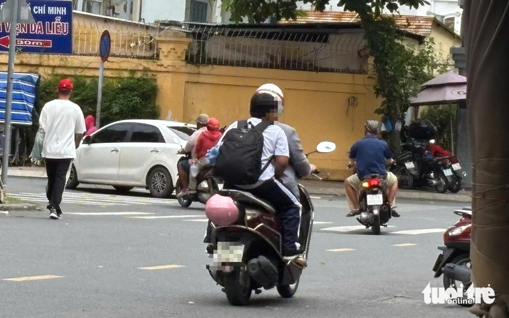 Nhiều phụ huynh 'vô tư' chở con chạy ngược chiều, leo vỉa hè, không đội mũ bảo hiểm đến trường - Ảnh 5.