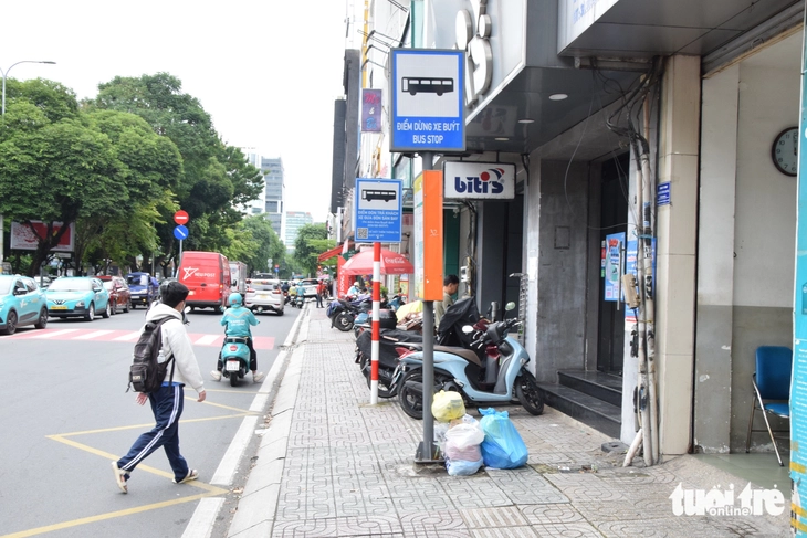 Ở nhiều trạm xe buýt TP.HCM khách đứng chờ phải bịt mũi - Ảnh 6.