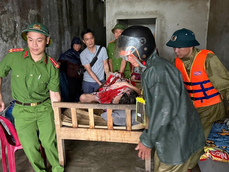 Chiến sĩ công an khiêng người dân bị tai biến đi sơ tán bão Bualoi - Ảnh 1.