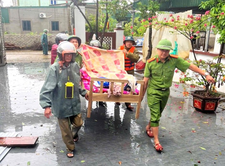 Chiến sĩ công an khiêng người dân bị tai biến đi sơ tán bão Bualoi - Ảnh 2.
