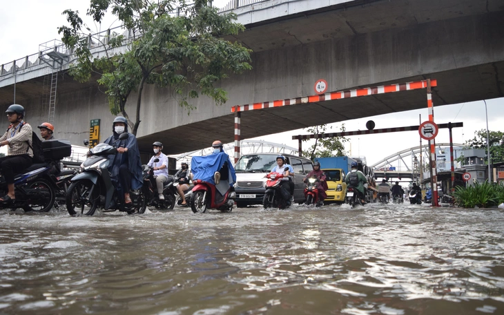 TP.HCM mưa hơn 160mm đúng giờ tan tầm, người dân bì bõm lội nước về nhà - Ảnh 6.