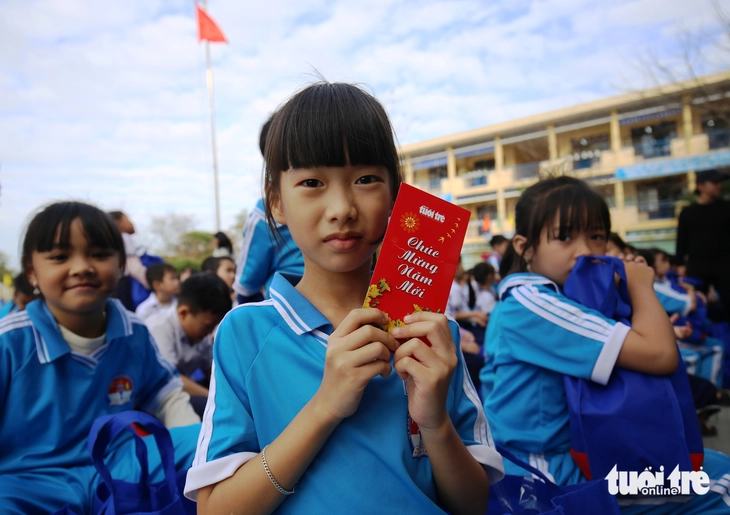 Quà Tết báo Tuổi Trẻ đến với học sinh vùng lũ: 'Mình sẽ đưa cho mẹ mua quần áo Tết' - Ảnh 1.