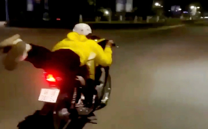 Không đội mũ bảo hiểm, buông cả 2 tay nằm dài trên xe khi lái xe máy - Ảnh 4.