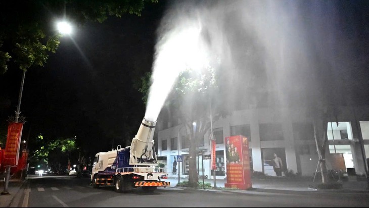 Máy phun sương dập bụi xuất hiện trên đường phố Hà Nội  - Ảnh 1.