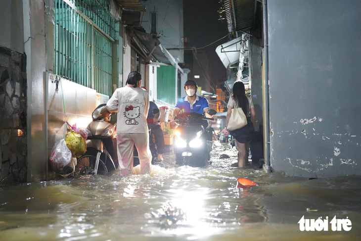 Người dân lội nước về nhà, trẻ em bơi giữa dòng triều cường đạt đỉnh - Ảnh 12.