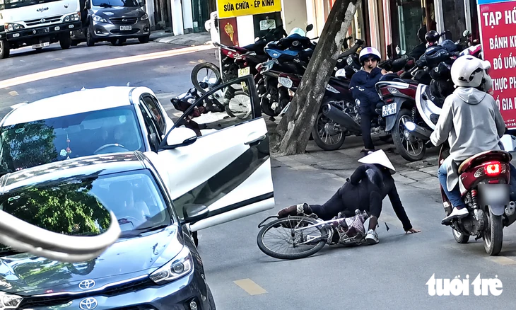 Nữ tài xế mở cửa ô tô bất cẩn gây tai nạn cụ bà đi xe đạp - Ảnh 1.