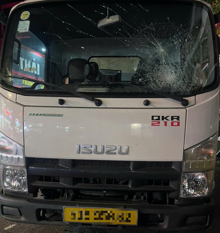 Triệu tập người đàn ông đi xe đạp điện cầm gậy đập vỡ kính xe tải ở TP.HCM - Ảnh 2.