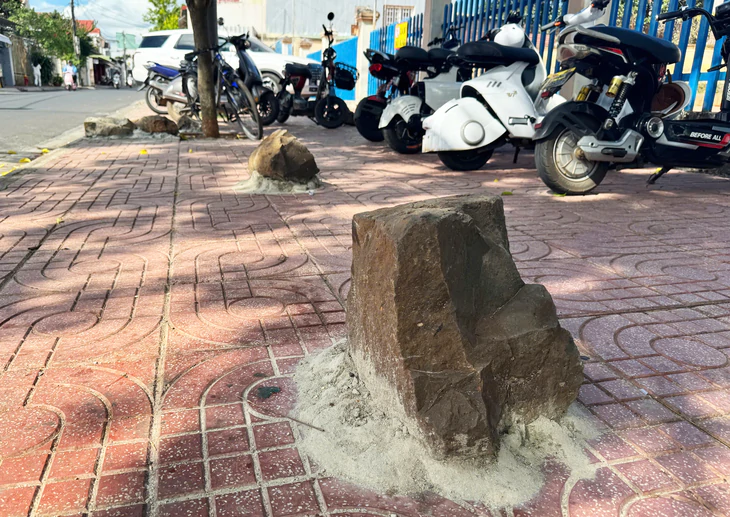 Hơn chục tảng đá được trát vữa cố định 'thù lù' trên vỉa hè trước trường - Ảnh 3.