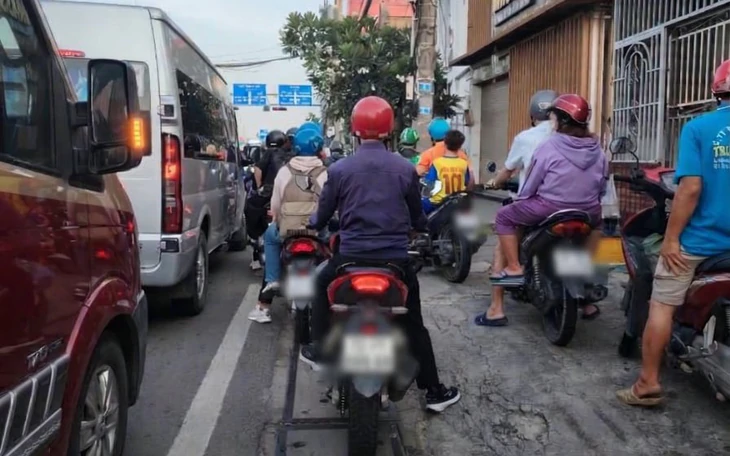 Khách nên tự dắt xe hay để người giữ xe lớn tuổi phải 'hóp bụng' dùng sức khi dắt? - Ảnh 2.