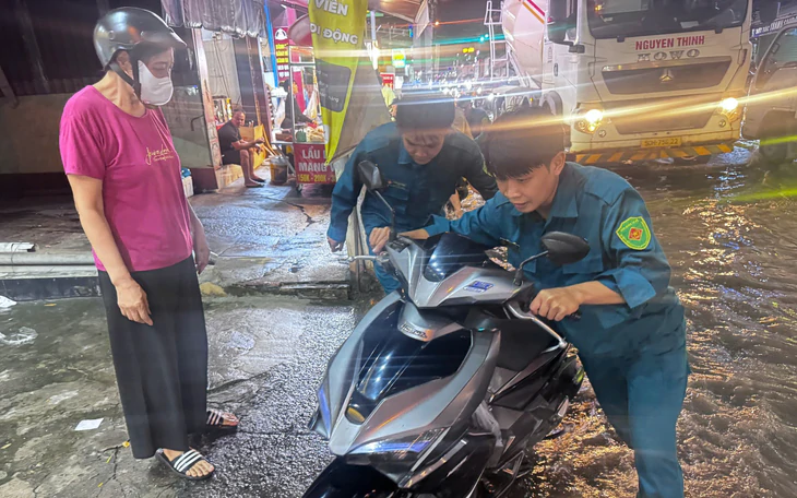 Triều cường bủa vây khu dân cư chung cư 136 Bùi Văn Ba, người dân thức đêm canh nước - Ảnh 2.