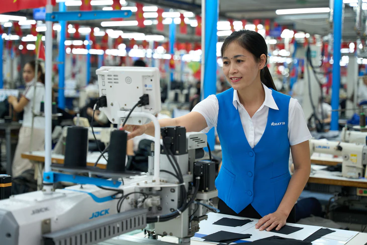 Nữ công nhân dùng máy lập trình cắt laser để tăng năng suất chuyền may - Ảnh 1.