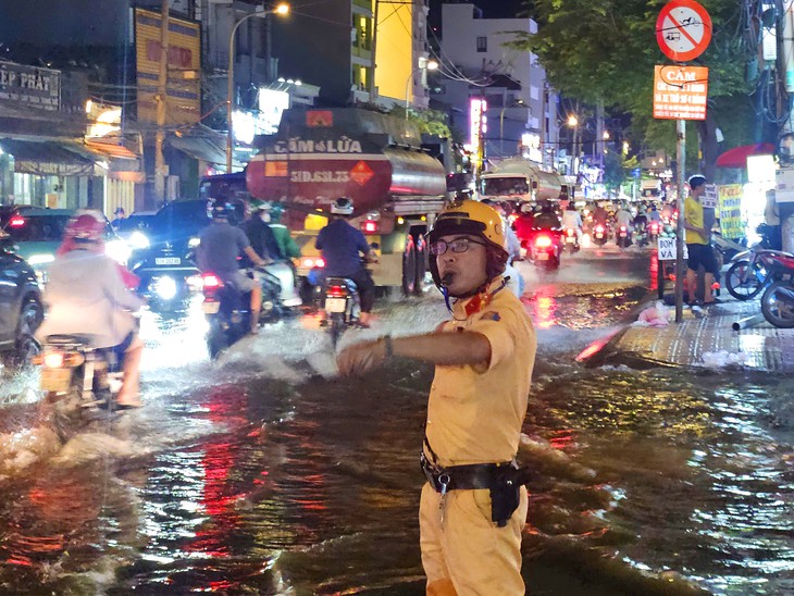 CSGT TP.HCM khuyến cáo người đi xe máy: Đi chậm, nhìn kỹ, đừng cố vượt ngập sâu - Ảnh 1.