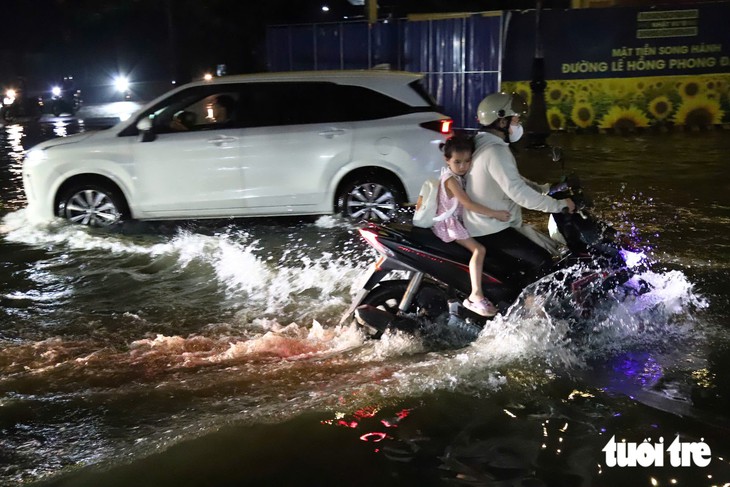 Đường gần chợ Thông Dụng, TP.HCM ngập sau mưa lớn, người dân sụp ổ gà té nhào - Ảnh 2.