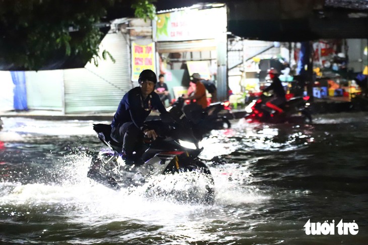 Đường gần chợ Thông Dụng, TP.HCM ngập sau mưa lớn, người dân sụp ổ gà té nhào - Ảnh 3.