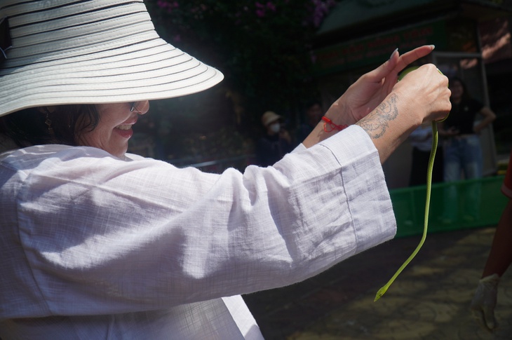 Du khách dạn tay ôm rắn chụp hình tại Trại rắn Đồng Tâm - Ảnh 9.