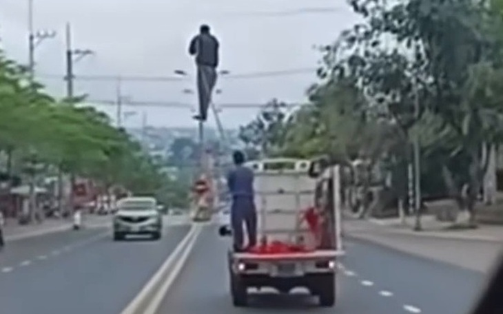 Tài xế lái xe biển xanh chở bàn ghế cồng kềnh và người ngồi phía sau thùng ở Huế xe bị xử phạt - Ảnh 2.