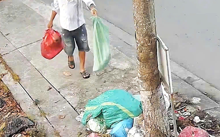 Lén vứt rác ven đường Nguyễn Văn Linh, hai người đàn ông bị camera phát hiện - Ảnh 3.