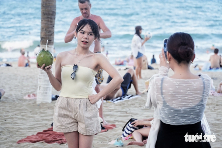 Biển Nha Trang đông nghẹt người dân, du khách đến 'giải nhiệt', hàng quán ven biển ăn nên làm ra - Ảnh 4.
