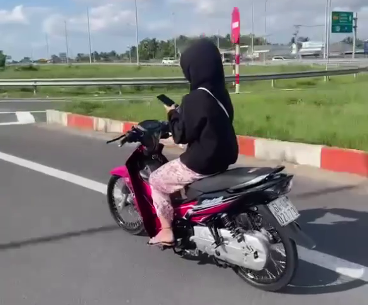 Thiếu nữ 15 tuổi vừa lái xe máy vừa dùng điện thoại, mẹ bị lập biên bản vì giao xe - Ảnh 1.