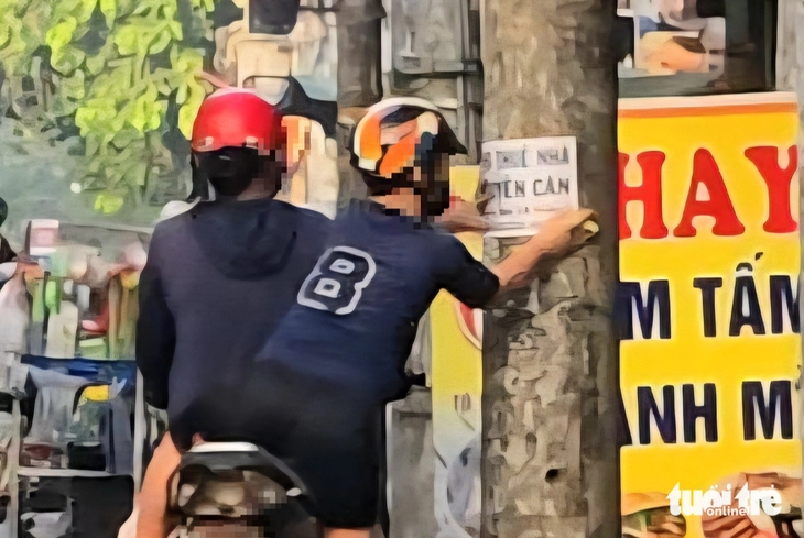 Vụ 'dán bậy' trên cột điện ở TP.HCM: Lập biên bản hai mẹ con, buộc tháo gỡ - Ảnh 1.