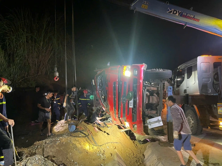 Giải cứu hai anh em ruột mắt kẹt trong cabin xe tải bị lật trên quốc lộ  - Ảnh 1.