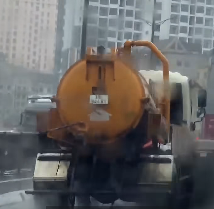 Xe bồn xả nước thải đen kịt trên đường Vành đai 3 Hà Nội giữa cơn mưa lớn - Ảnh 1.