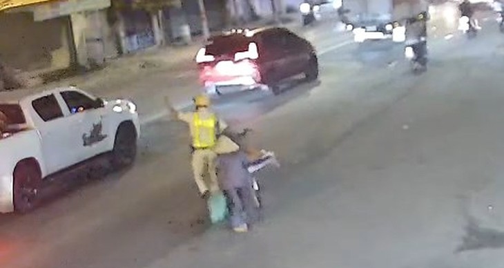 Dừng lại giữa dòng xe, Cảnh sát giao thông dắt xe giúp cụ bà qua đường nhận mưa lời khen - Ảnh 2.