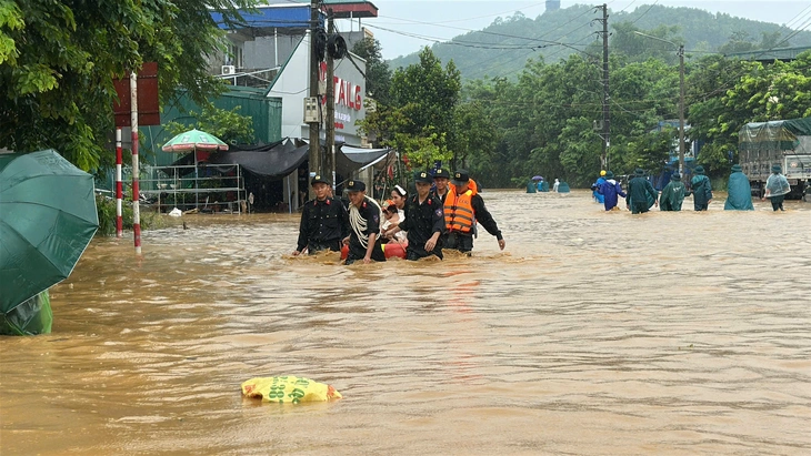 Cảnh sát dầm mưa đưa người dân, tài sản khỏi vùng ngập sâu - Ảnh 1.
