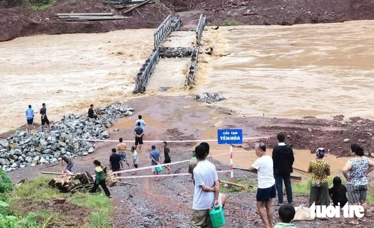 Mưa lũ cuốn đứt cầu tạm, chia cắt hơn 400 hộ dân miền núi Nghệ An - Ảnh 1.