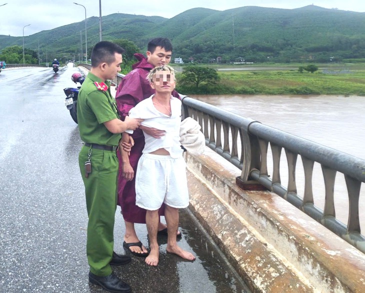 Nam thanh niên "làm xiếc" trên lan can cầu ở Phong Nha, đại úy công an kịp thời ngăn chặn - Ảnh 2.