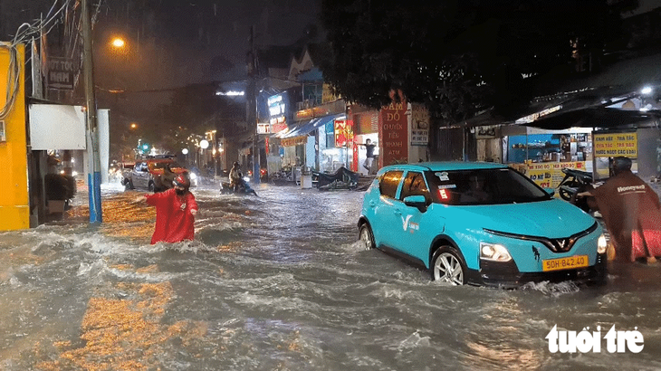 Nước cuồn cuộn như thác, xô ngã người dân trên đường Lý Tế Xuyên ở TP.HCM - Ảnh 1.