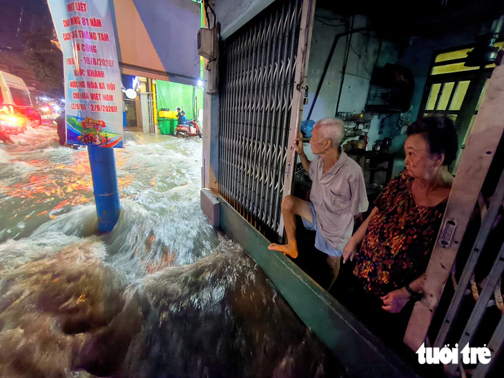 Nước cuồn cuộn như thác, xô ngã người dân trên đường Lý Tế Xuyên ở TP.HCM - Ảnh 2.