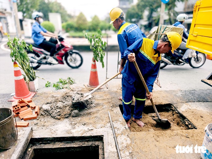 Khắc phục 'hố tử thần' gần trường học, xuất hiện sau mưa lớn ở TP.HCM - Ảnh 1.