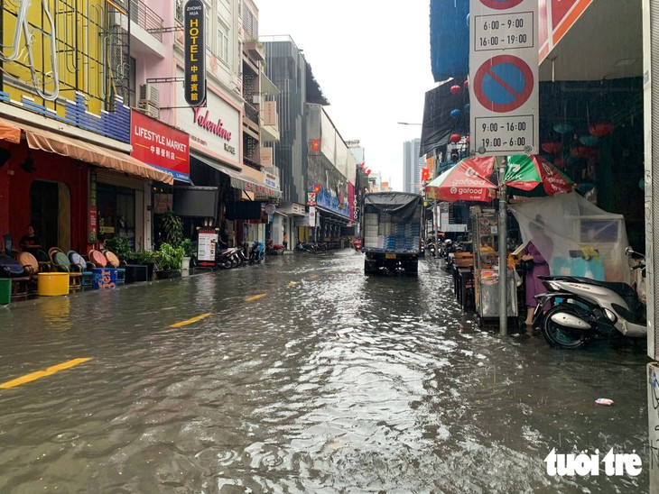 Khu trung tâm TP.HCM ngập nước sau 1 giờ mưa lớn - Ảnh 1.
