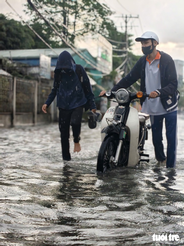 Ngã tư Nguyễn Văn Khối - Lê Văn Thọ ở TP.HCM ngập sâu, học sinh dắt xe lội nước về nhà - Ảnh 7.