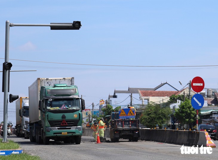 Ổ gà nguy hiểm trên quốc lộ 1, người dân tự lấy cây làm dấu cho tài xế tránh né - Ảnh 3.